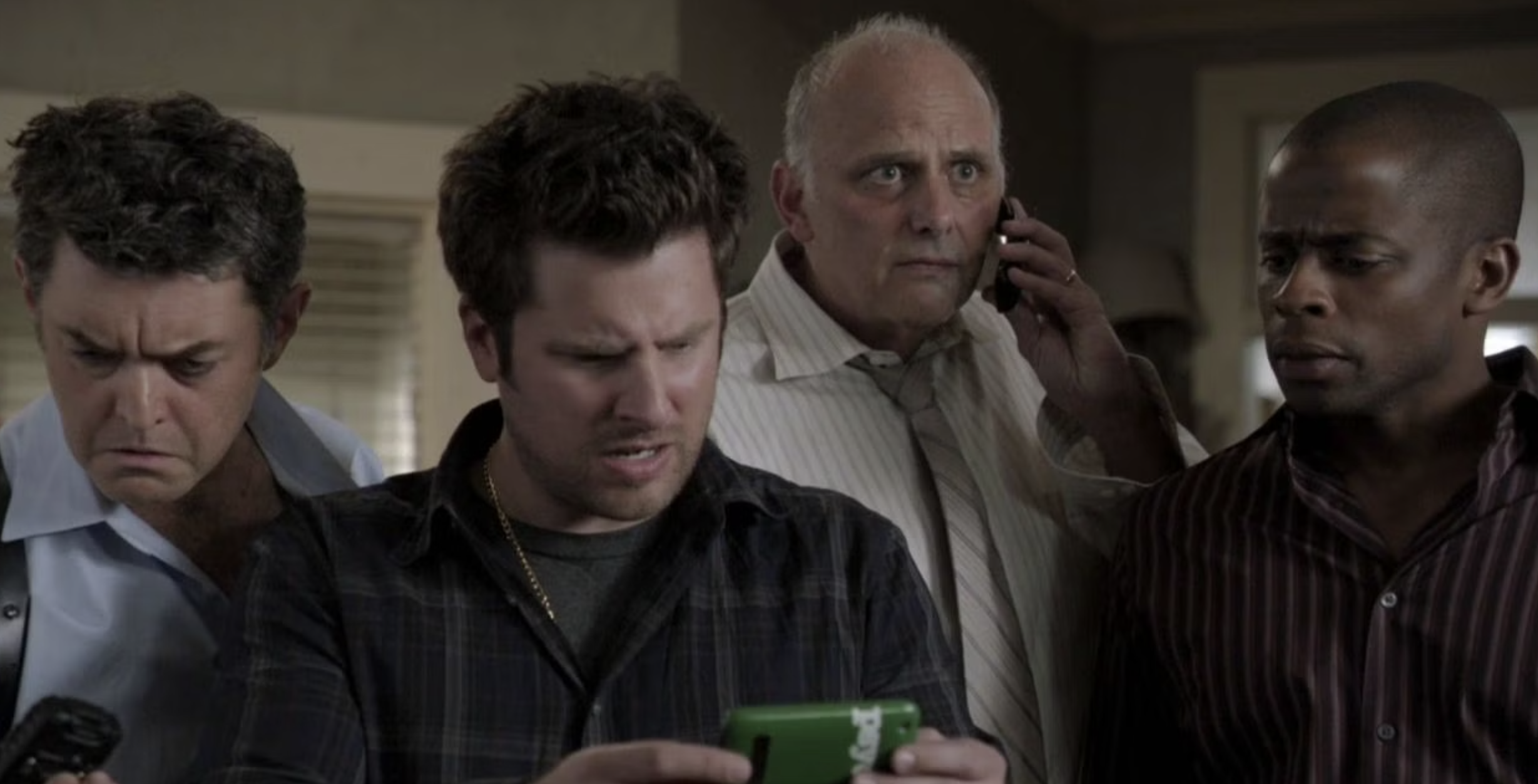 Lassiter, Shawn, Woody, and Gus all look at Shawn's phone in confusion.