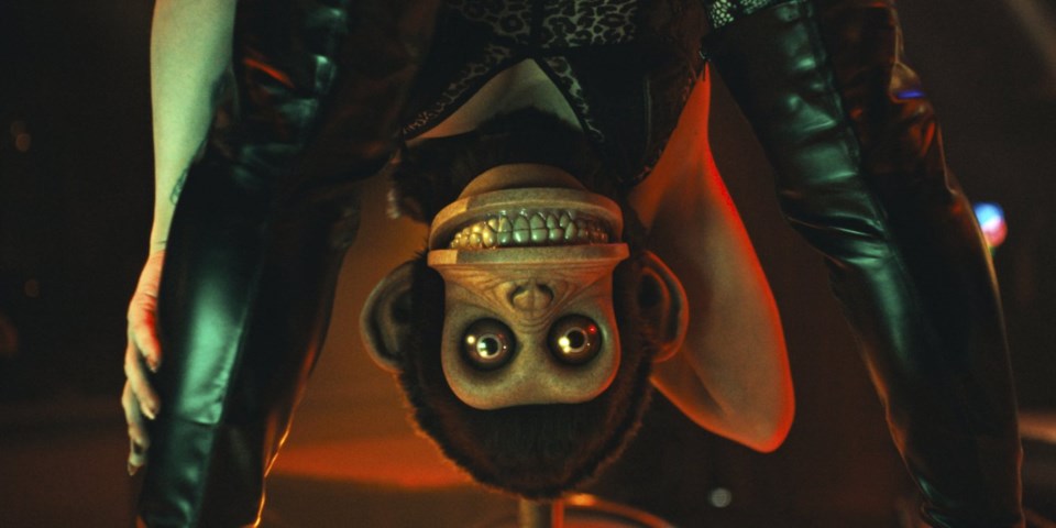 A stripper leans down, the monkey's face taking over hers. Perkins, Osgood. The Monkey, 2025.