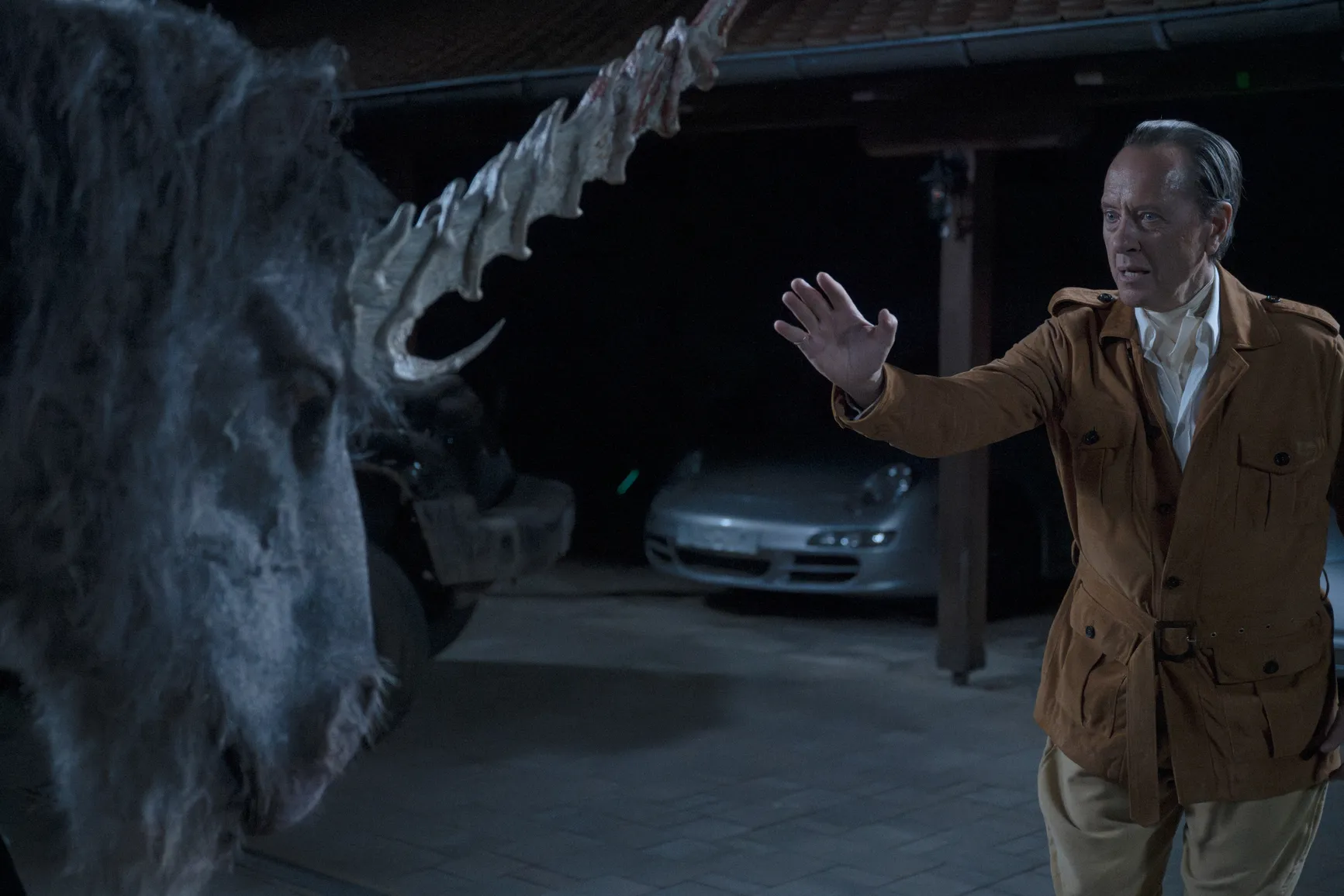 Black unicorn threatens a millionaire CEO with his imposing horn. Scharfman, Alex. Death of a Unicorn. 2025.