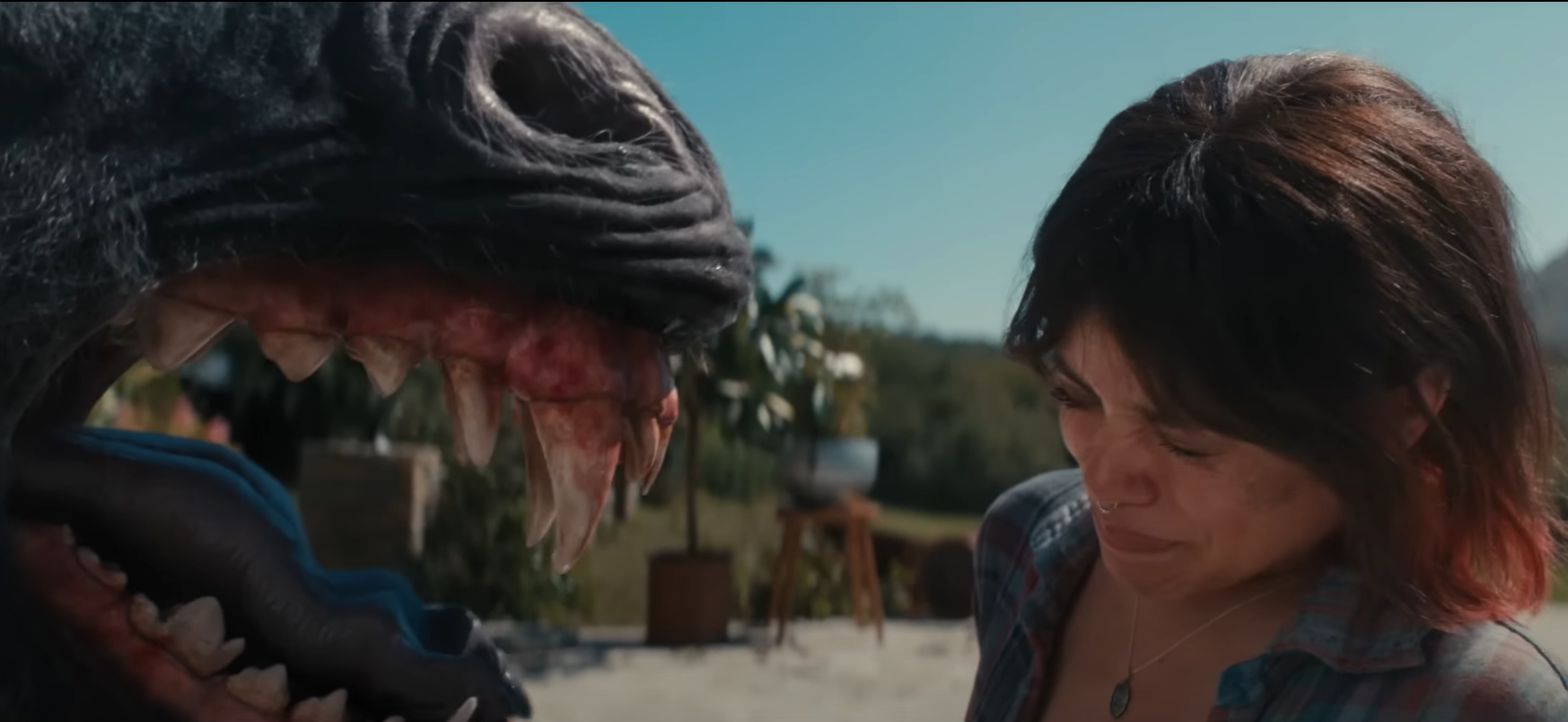 Ridley (Jenna Ortega) faces a black unicorn, afraid. Scharfman, Alex. Death of a Unicorn. 2025.