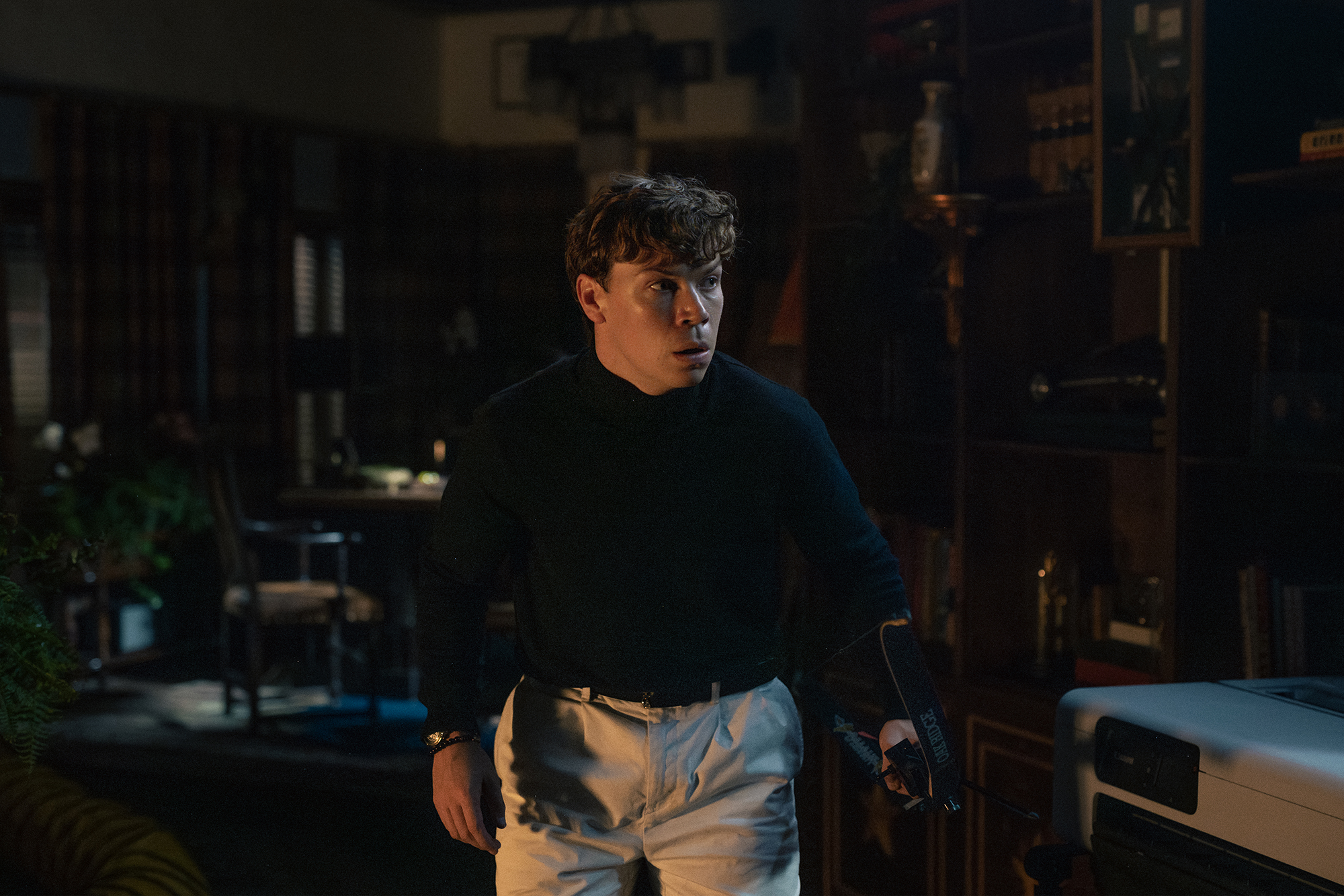 Shephard (Will Poulter) stands guarded and afraid. Scharfman, Alex. Death of a Unicorn. 2025.