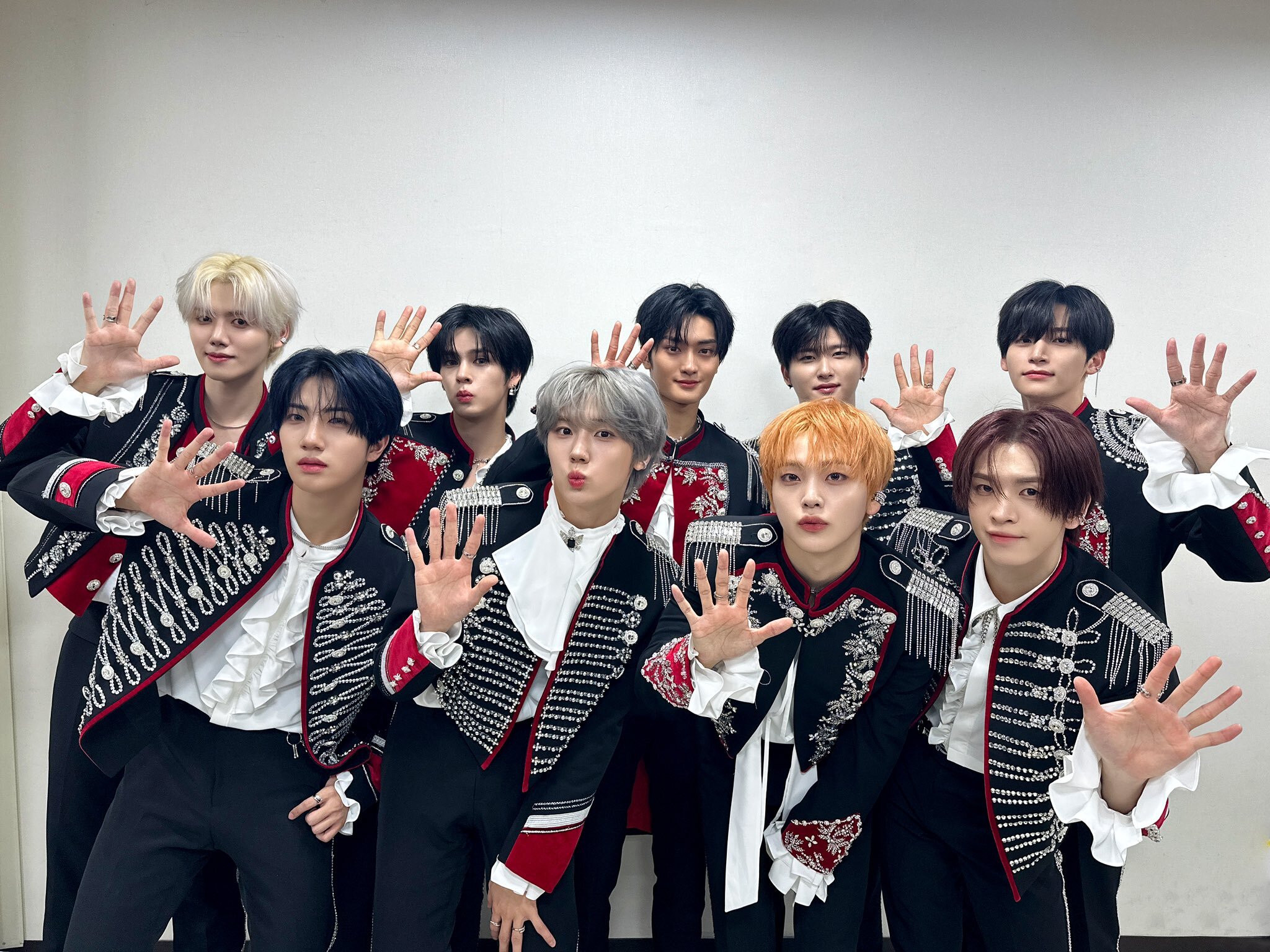 Cravity pose with the number 5 hand signal for fans to vote for them on Road to Kingdom: Ace of Ace.