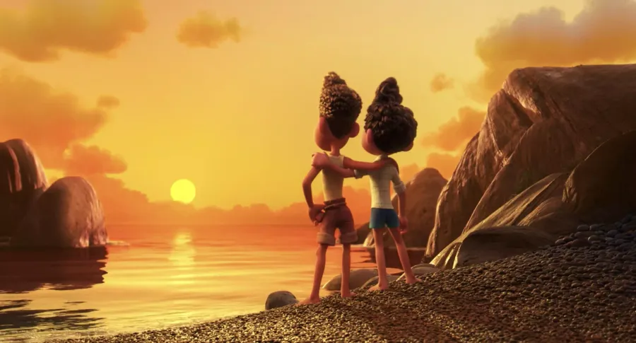 Luca and Alberto stand side-by-side on the shoreline and gaze out over the sunset with their arms draped around each other's shoulders.