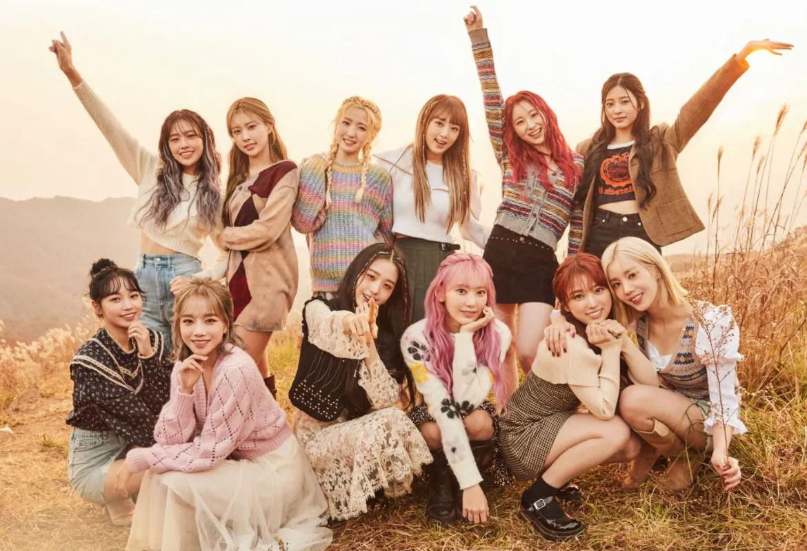 IZ*ONE members pose in a field.