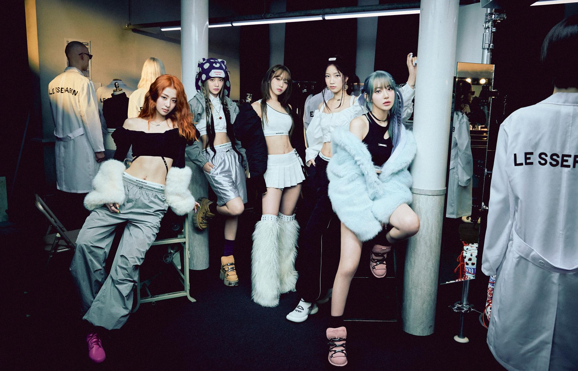 LE SSERAFIM members Yunjin, Eunchae, Chaewon, Kazuha, and Sakura pose in a backstage setting.