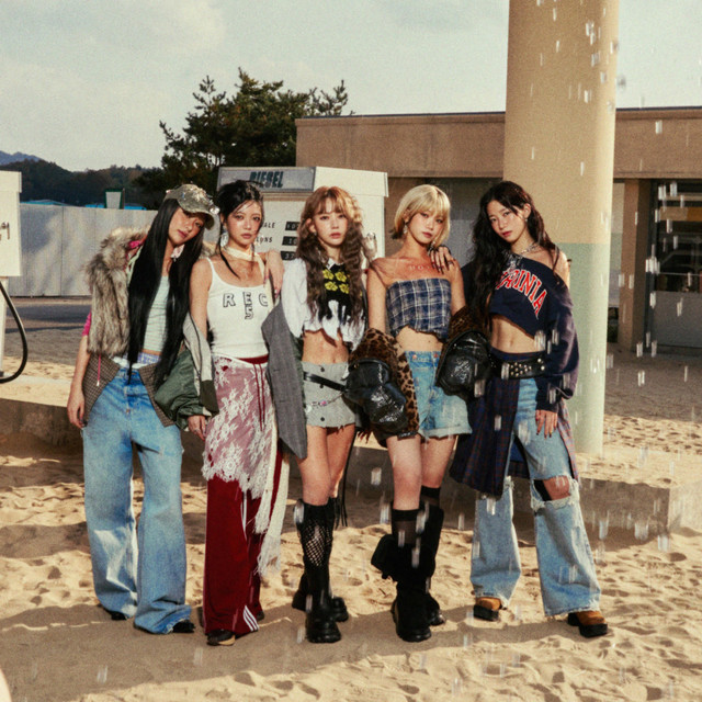 LE SSERAFIM members Sakura, Yunjin, Eunchae, Chaewon, and Kazuha pose in front of an obscured building.
