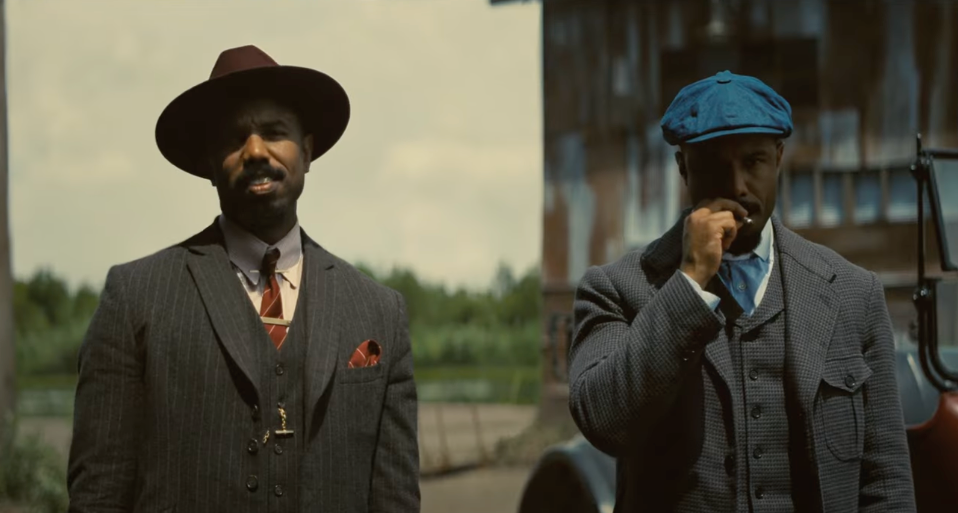 Twins Stack and Smoke (Michael B. Jordan) stand in front of their juke joint facing the camera.