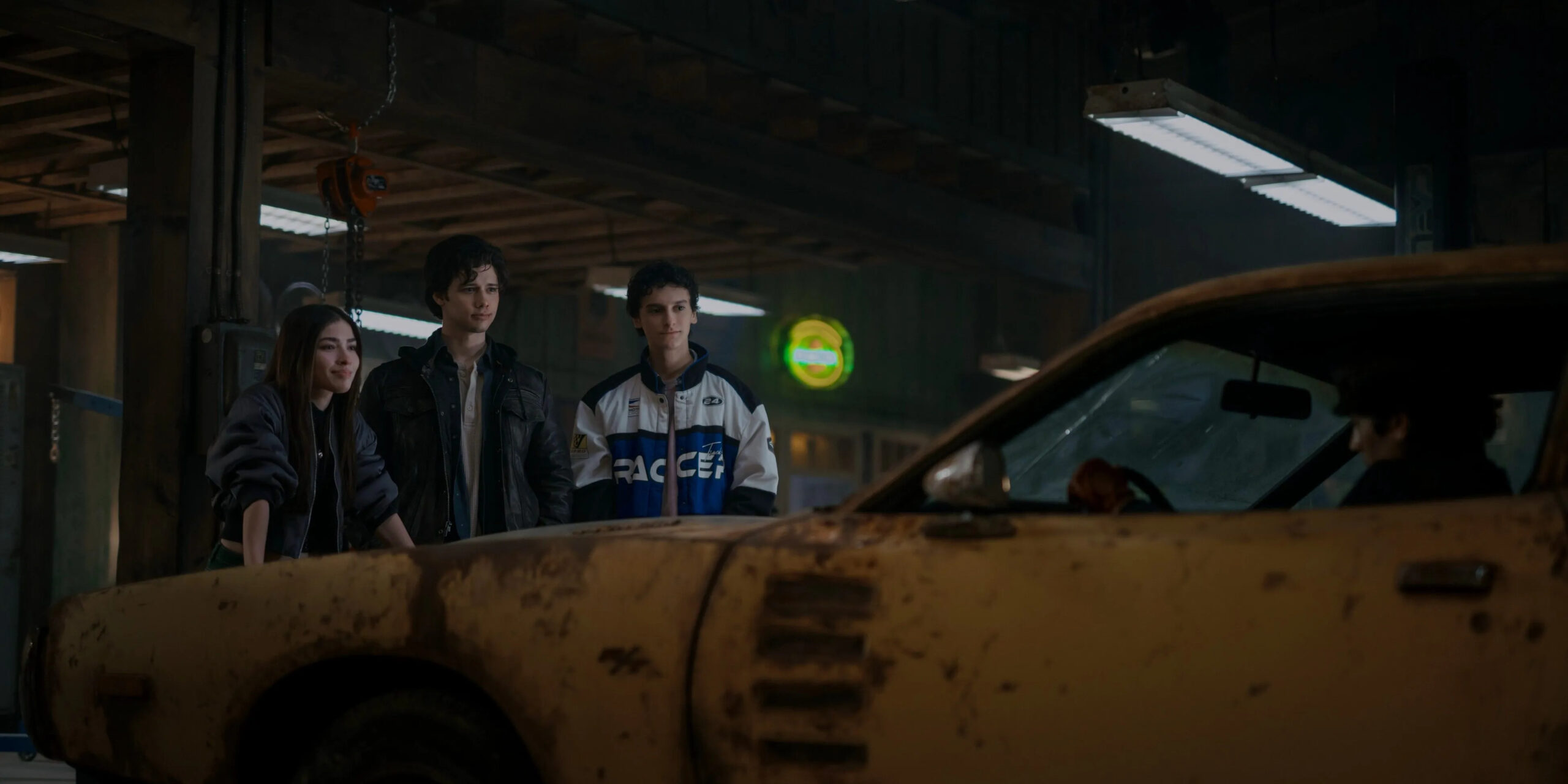 Caitlyn, Zac, Curtis and Marcel in the twin's garage work on the twin's father's car. 