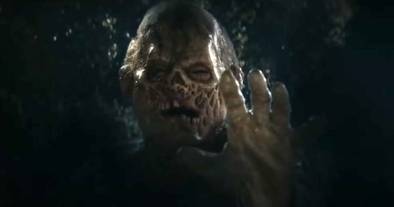 The zombie from There's A Zombie Outside reaching through bushes towards the camera.