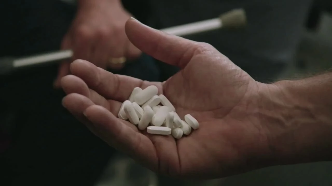 House holding a handful of pills from the show tackling his drug addiction. Shore, D., Attanasio, P., & Jacobs, K. House, M.D.. Fox. 2004–2012.