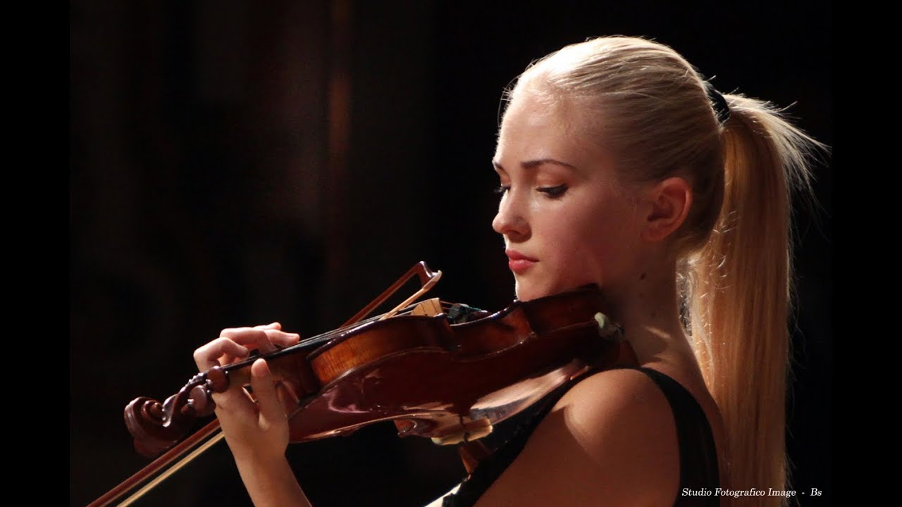 A woman playing the violin. Melodious Heart. “3 Beautiful & Talented Female Violinists I Recently Discovered.” YouTube. March 30, 2018.