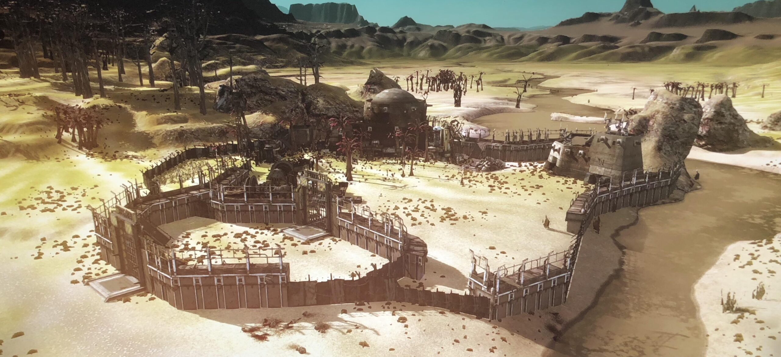 A medium-sized player base, located near a river in a grassland. It is composed of a few buildings and crops protected by sturdy walls. 