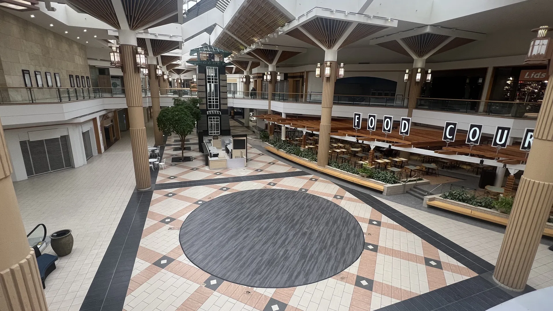 A shot of an empty mall from the second floor, overlooking a food court and expansive seating.