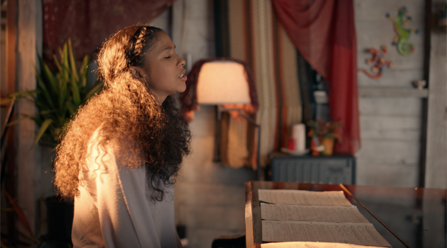 Julie singing "Wake up" at the piano, a tear streaming down her cheek.
