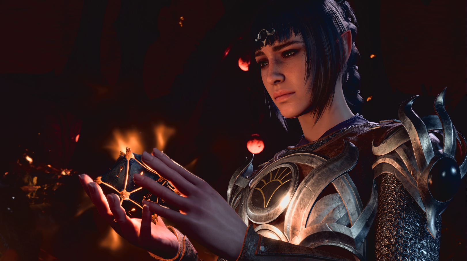 A woman with black hair and slightly pointed ears holds a glowing artifact within her hands.