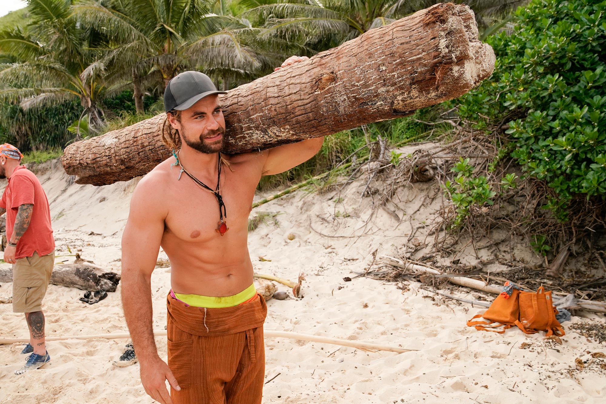 Jonathan Young proving his strength by carrying a log on his shoulder.