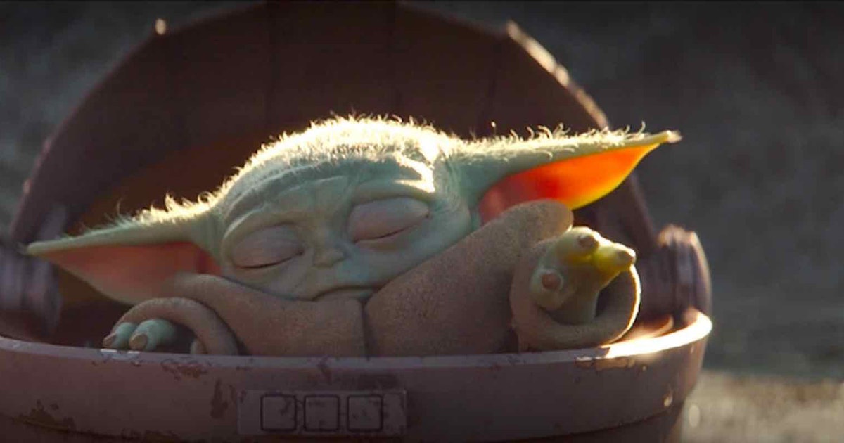 Grogu sits inside his hover pram with his eyes closed while he attempts to use the Force. 