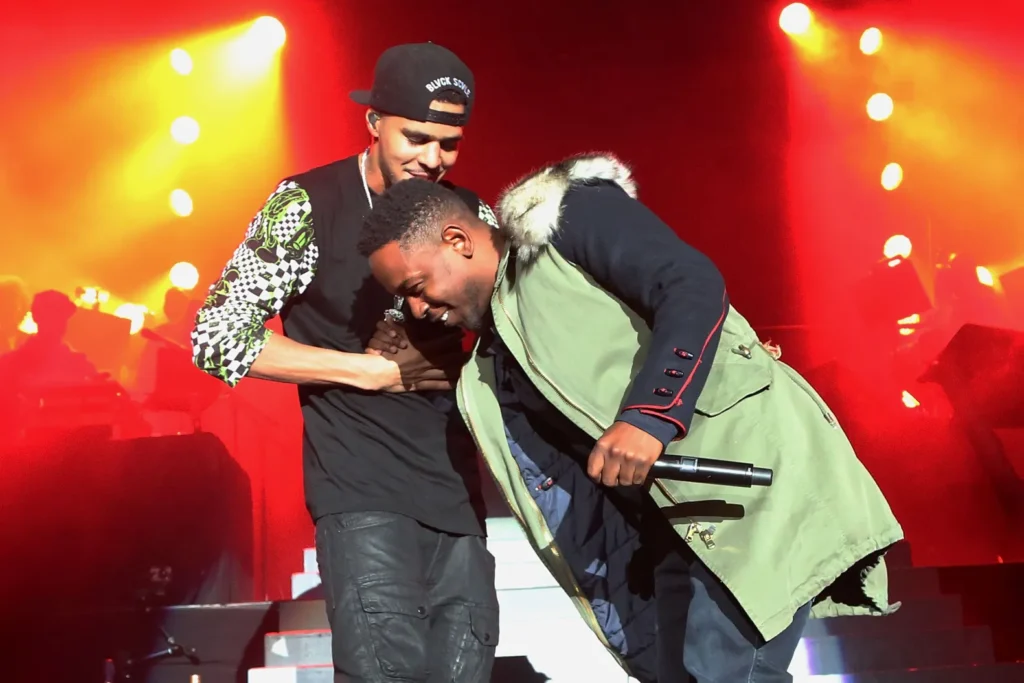 Kendrick Lamar and J. Cole greeting each other.