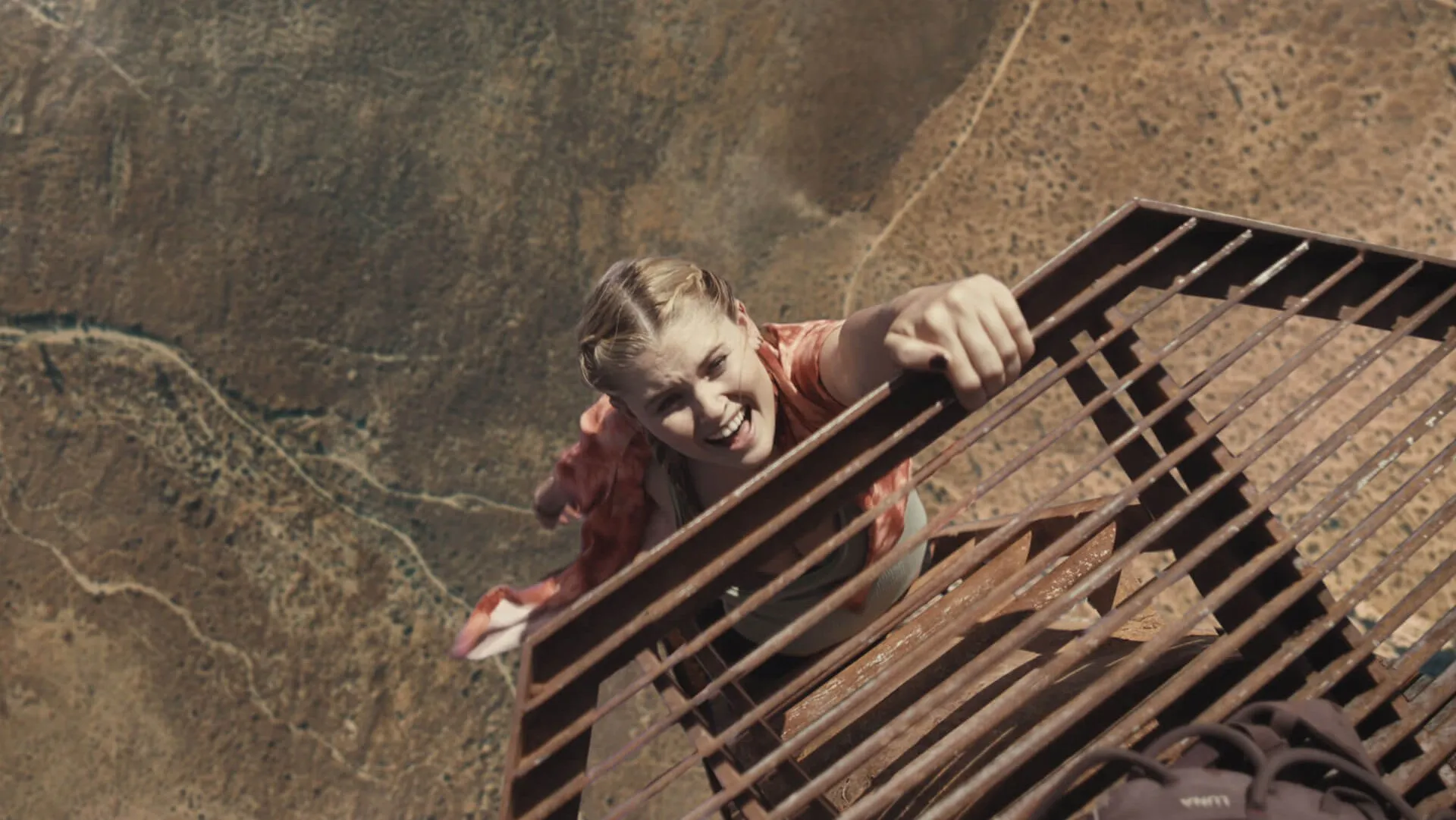 Fall's Hunter hanging by one hand from a high radio tower.