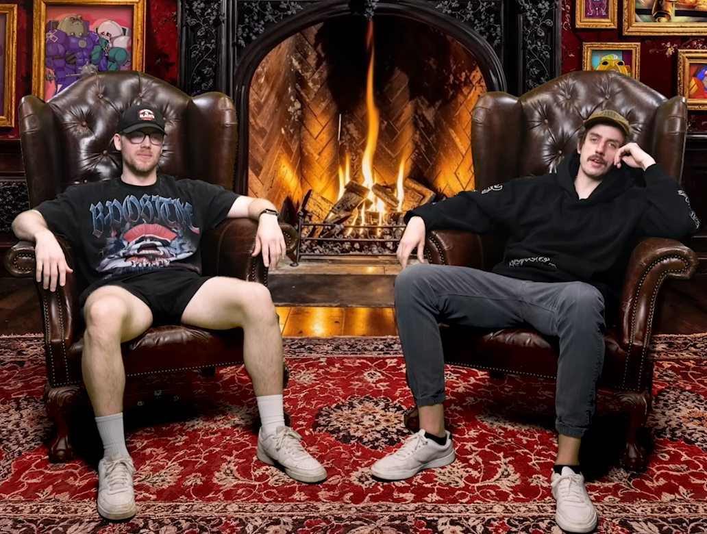 Tom (left) and Don (right) sit in-front of a CGI fireplace, with fan art across its walls.