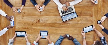 A team of millennials using various types of technology
