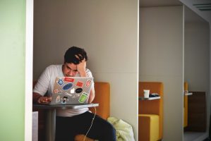 Stressed employee works at laptop