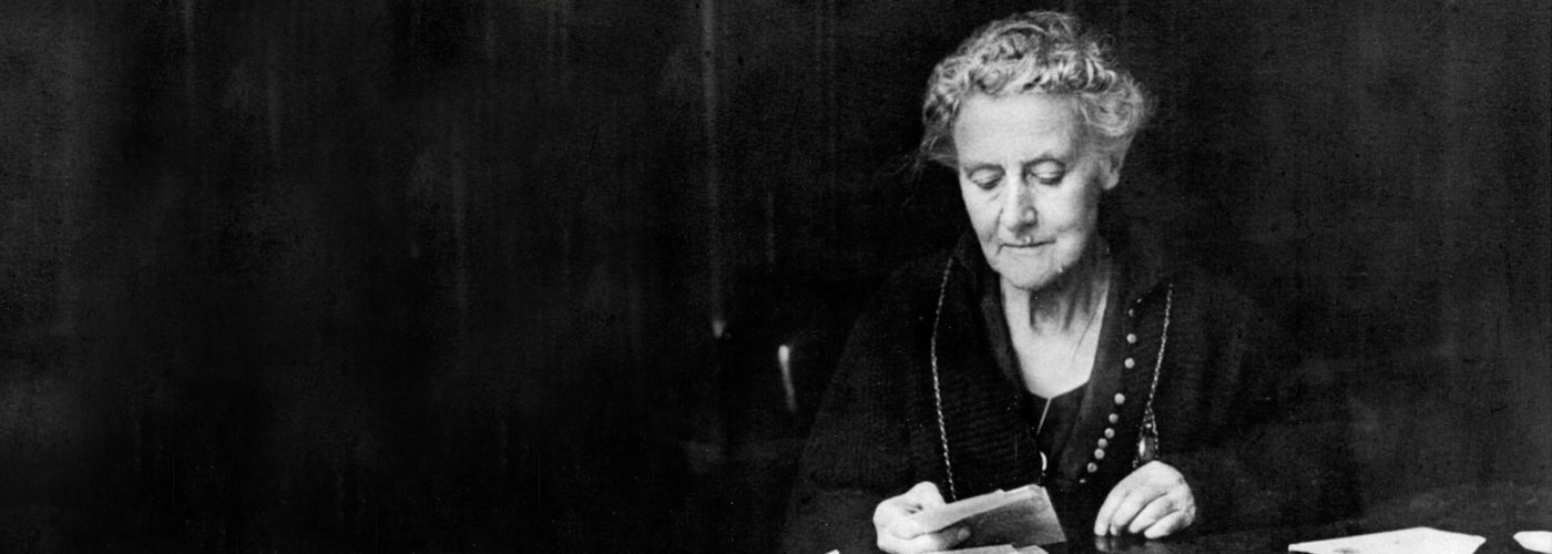 World Horse Welfare Founder, Ada Cole, sitting at a desk reading from a paper