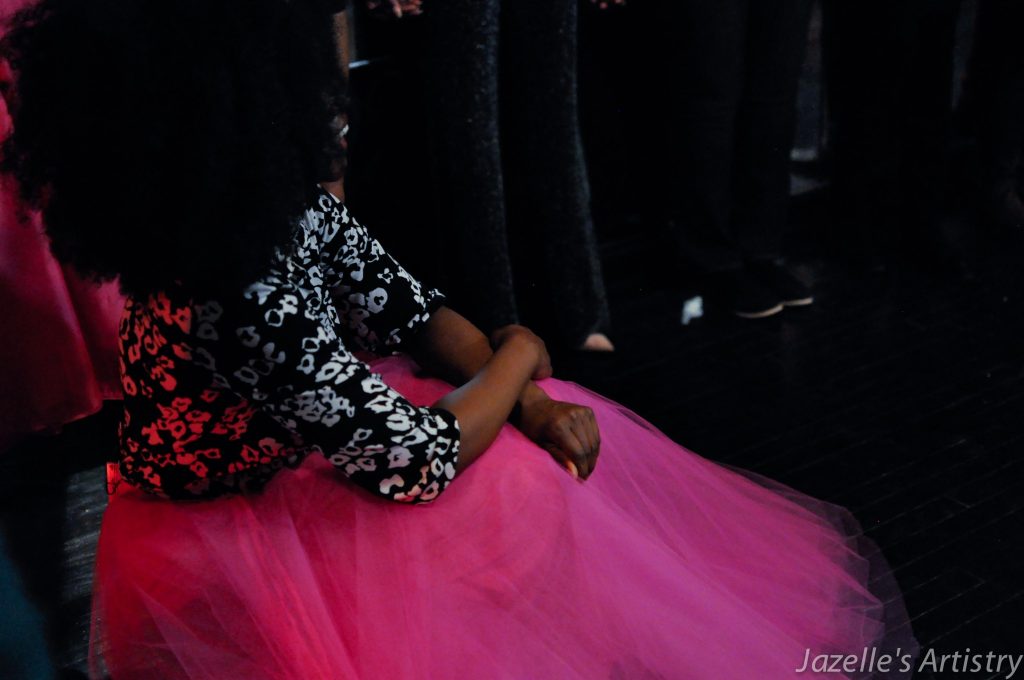 Sacred Bombshell Abiola Abrams in pink tutu skit and afro