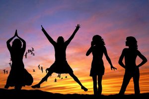 Silhouette of four people standing in front of a sunset