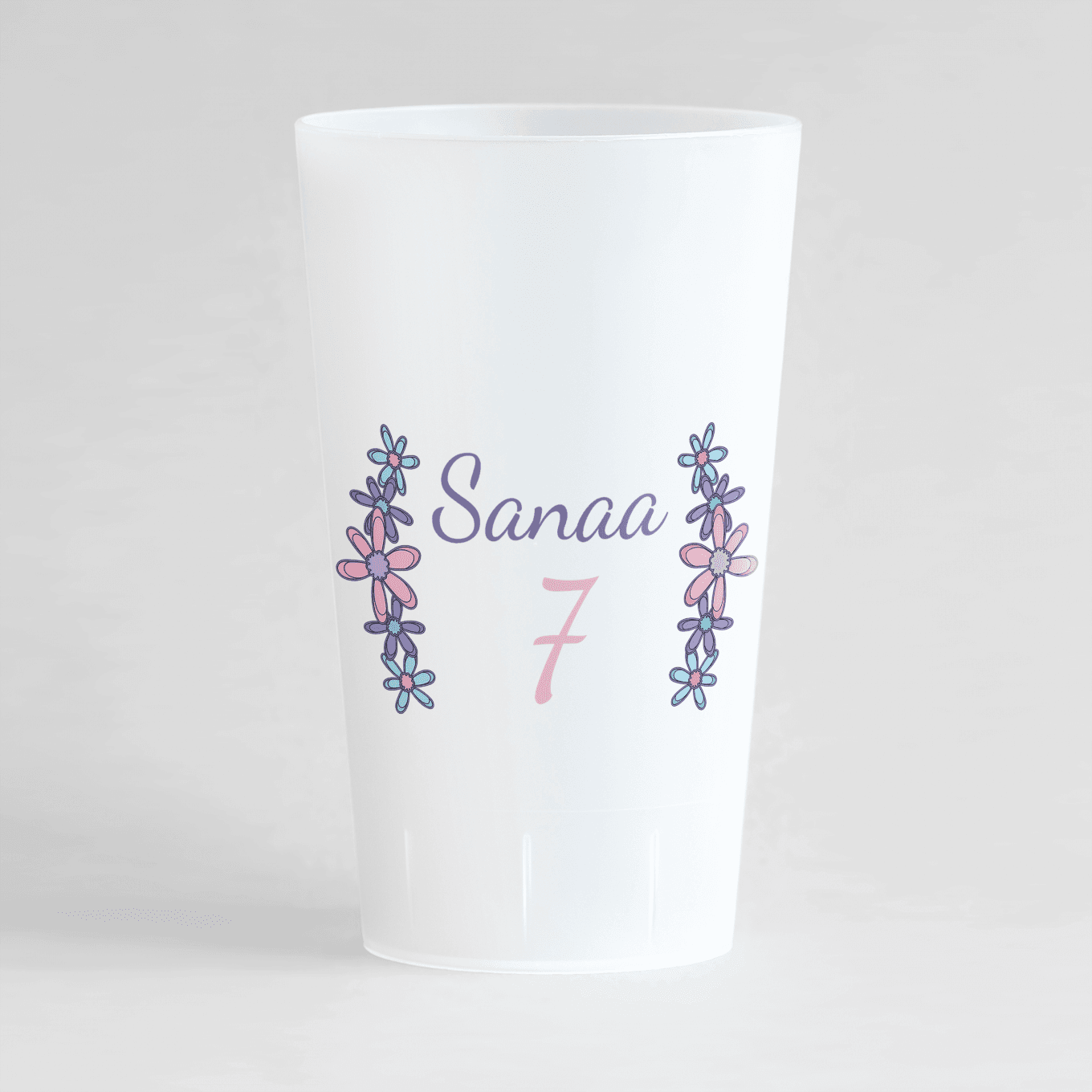 Un ecocup givré de dos avec une couronne de fleurs entourant prénom et âge pour un anniversaire.