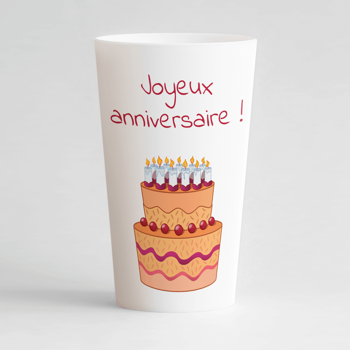 Un ecocup blanc de face avec un thème anniversaire, un gros motif gâteau et une inscription "joyeux anniversaire".