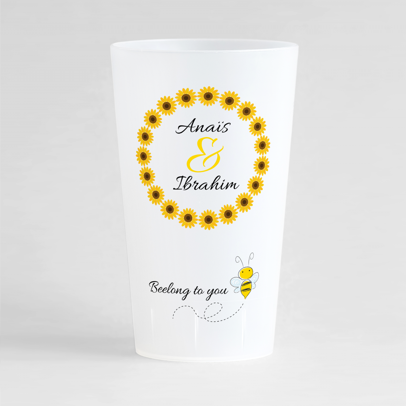 Un ecocup givré de face avec une couronne de tournesols autour des noms des mariés, et une phrase humour avec une abeille.