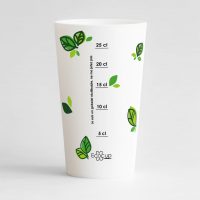 Un ecocup blanc de dos avec une graduation et des petites feuilles vertes en décoration.