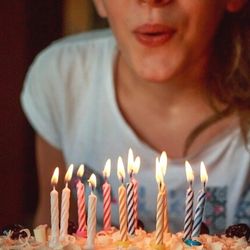 anniversairephoto Femme soufflant les bougies d'un gâteau d'anniversaire