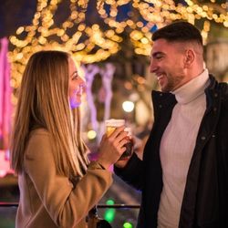 Couple trinquant sous les lumières de Noël