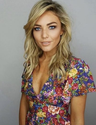 Sam Frost with blonde highlights and balayage hair colour. Side parting with soft waves and hair extensions