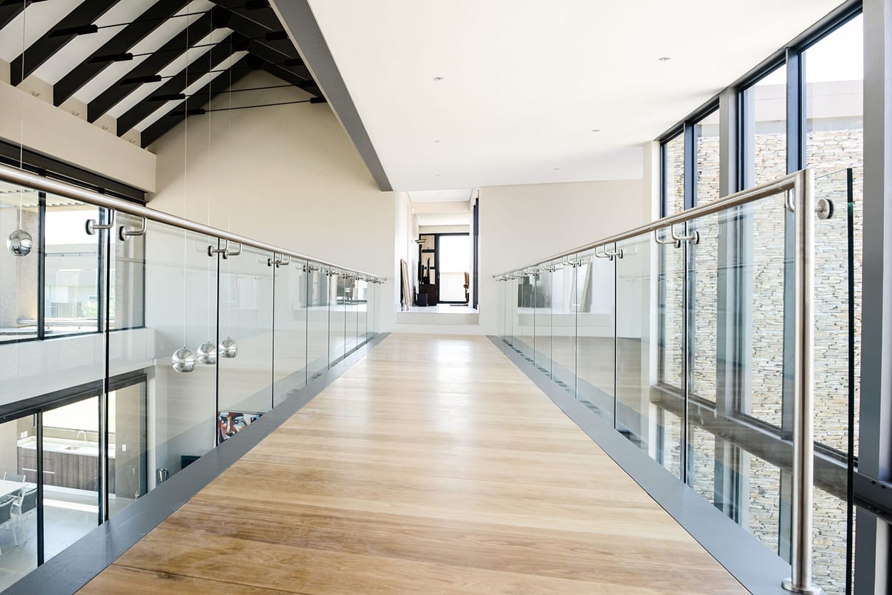 steel studio frameless glass balustrade on walkway with steel handrail