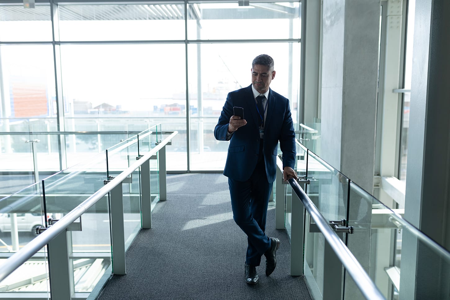 man leaning on a glass balustrade in a office building