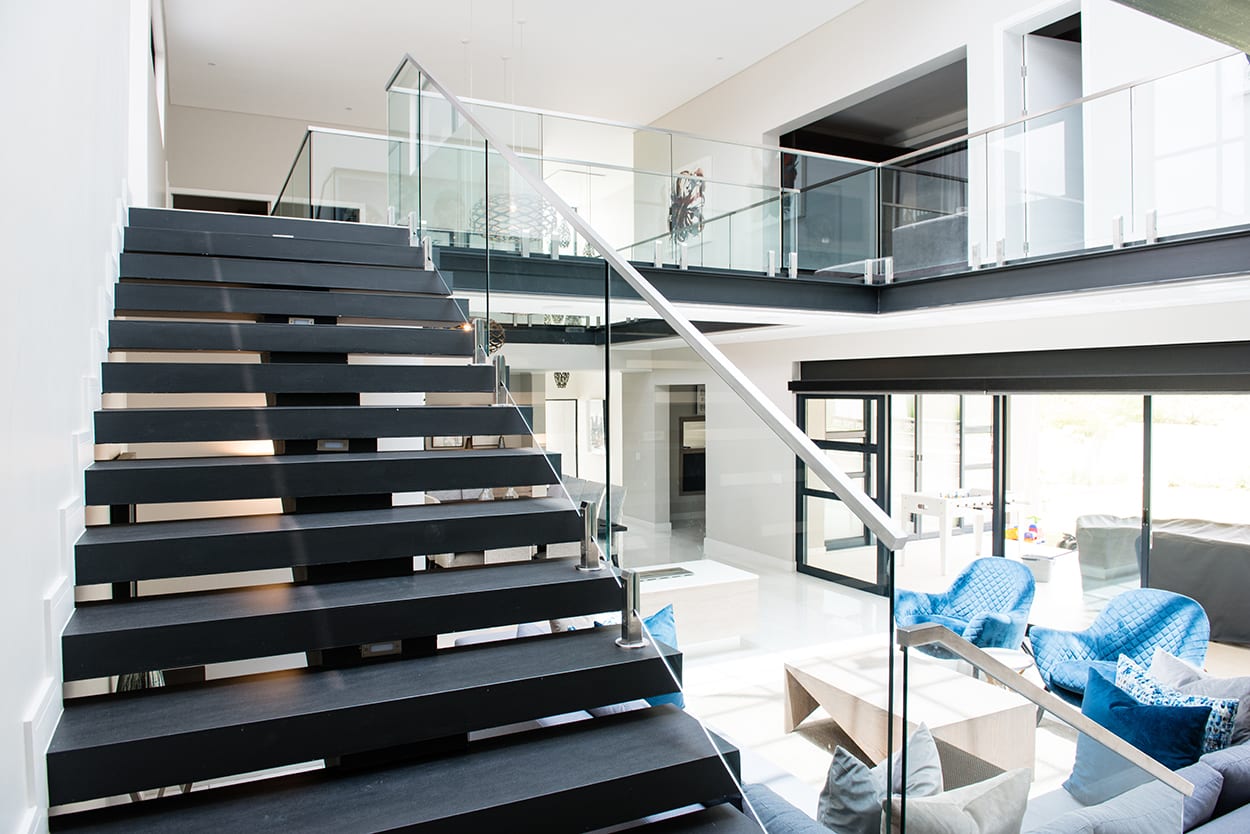Steel studio glass balustrades with handrail on staircase.