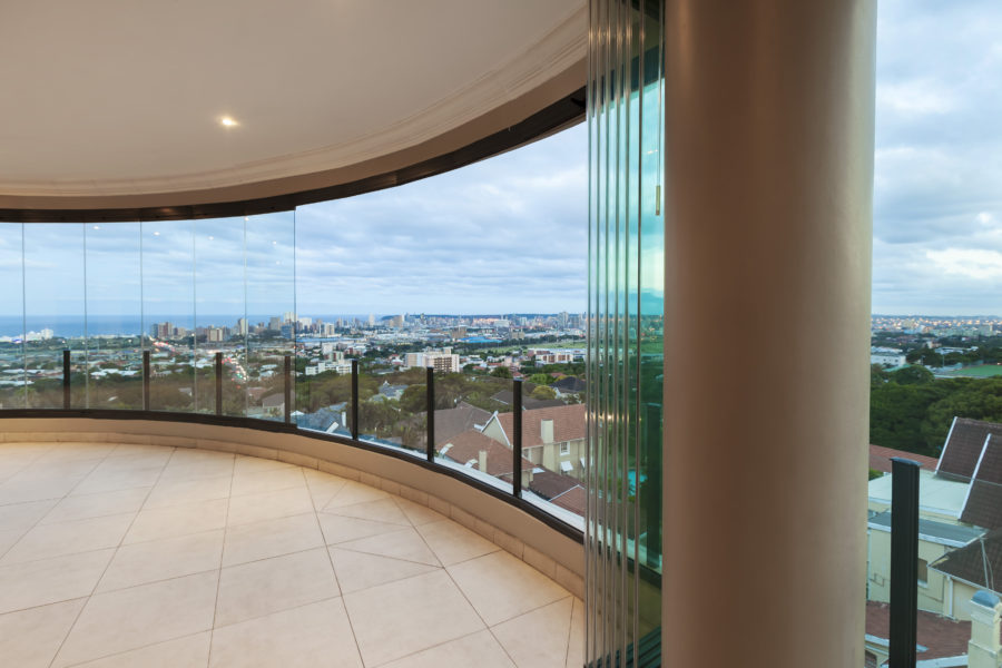 Sunflex SF25 Slide and Turn System seamlessly integrated into an existing curved balcony.