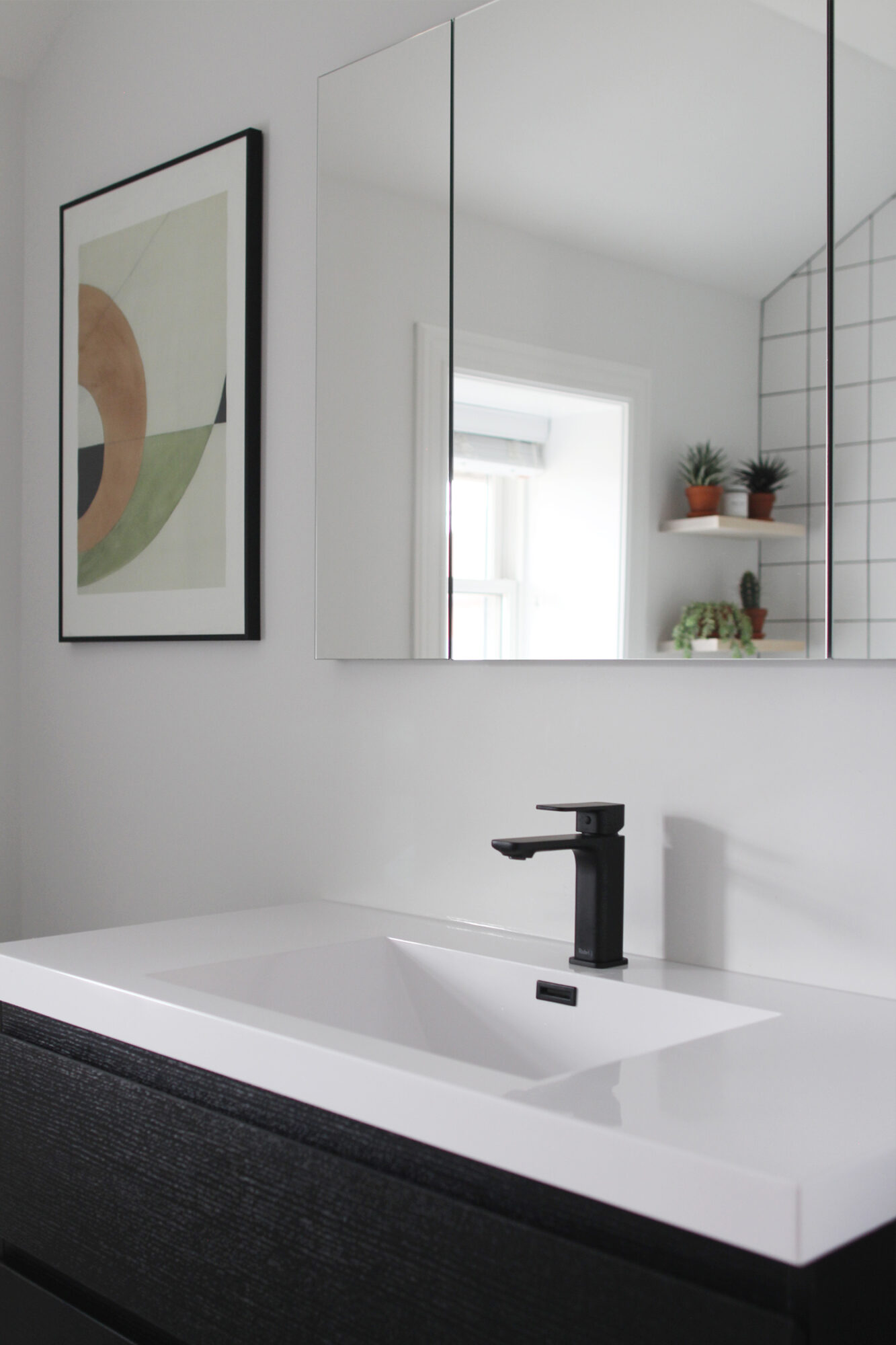 You're welcomed into the bathroom by a massive monstera and a flood of natural light from the window.