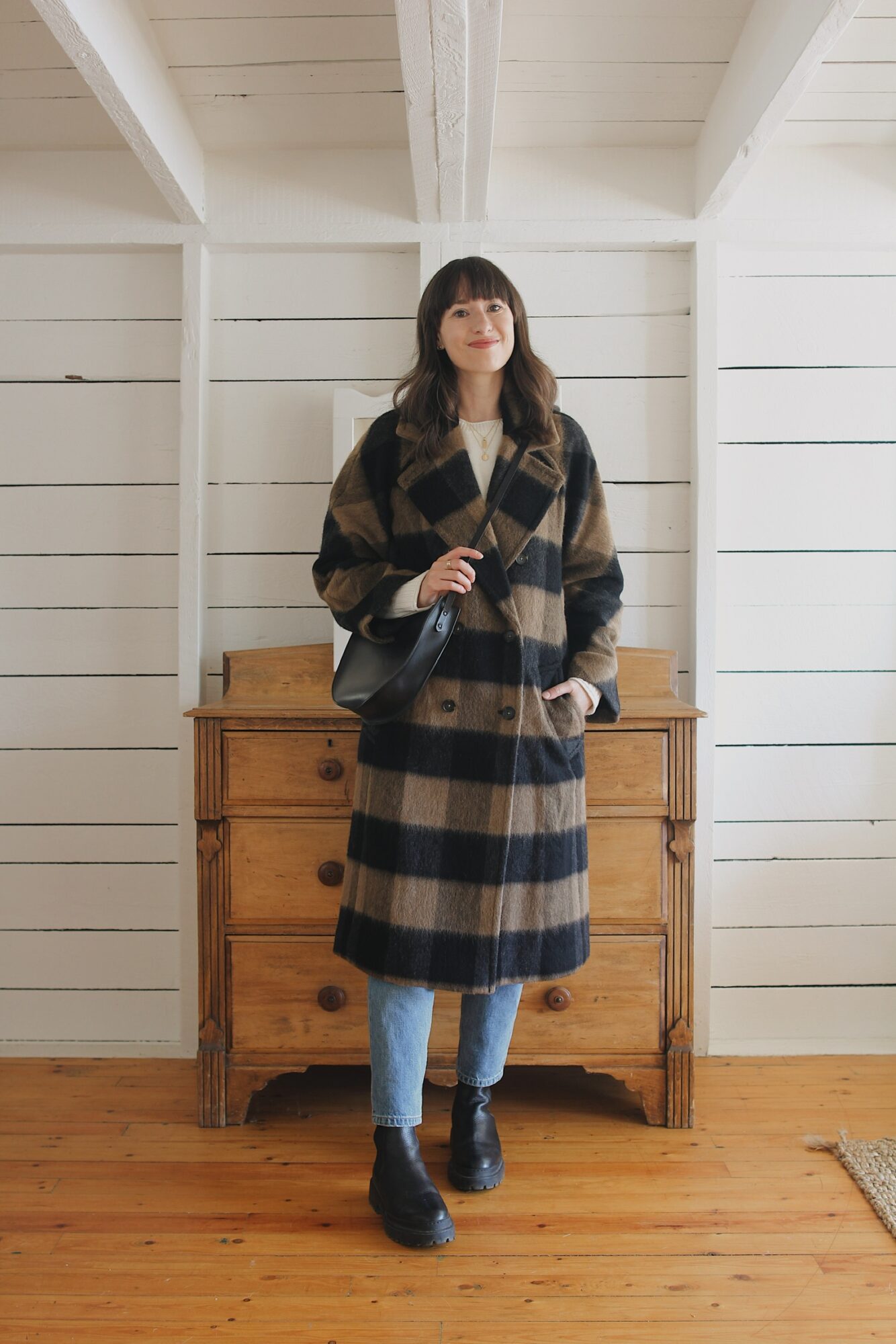 Style Bee wearing buffalo check wool peacoat, jeans, chunky boots and a black crossbody bag.