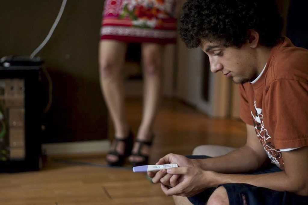 man holding pregnancy test