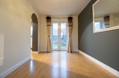 A brand new modern British home showing the dining room with newly fitted wooden floors looking out to the garden