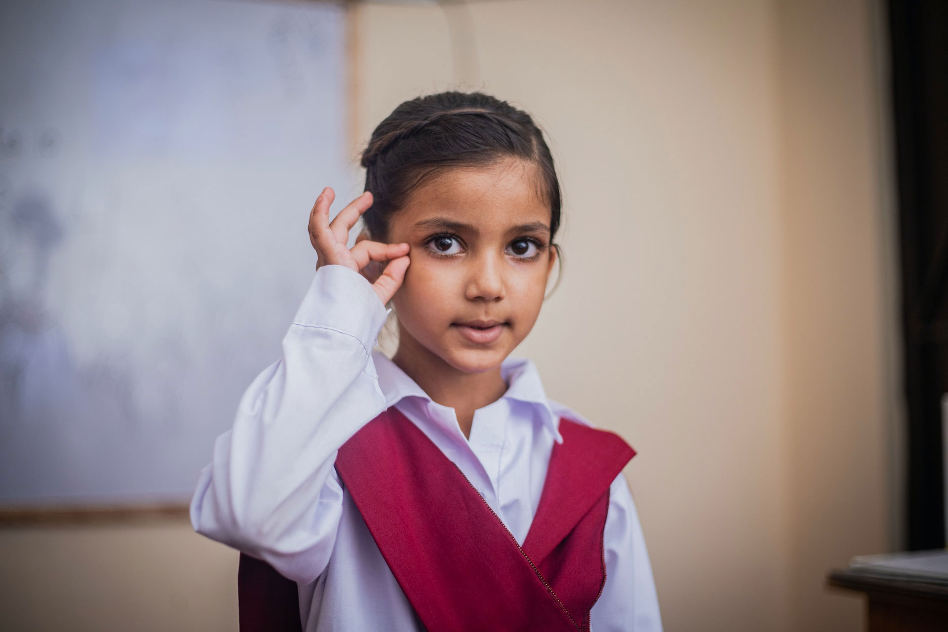 girl wearing red vest and white shirt