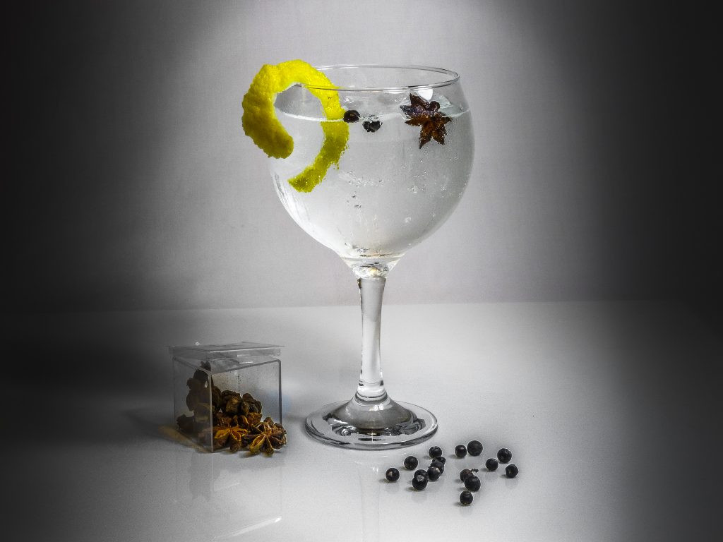 copa de Gin Anís con una rodaja de limón de decoración, pimienta y una estrella de anís.