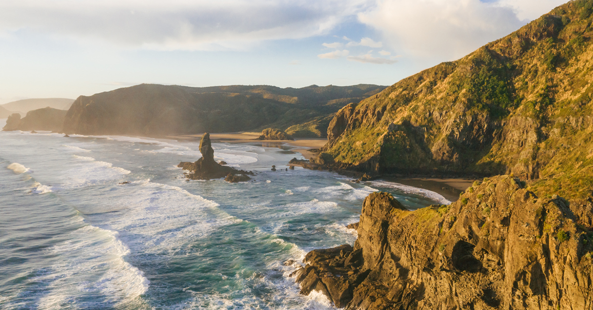 Rugged West Auckland coastline captured from above at sunset