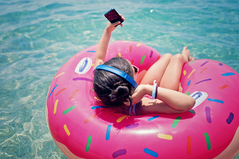 Girl in pool, listening to music