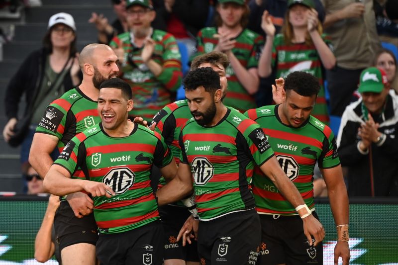 Group of Rabbitohs players celebrate on field