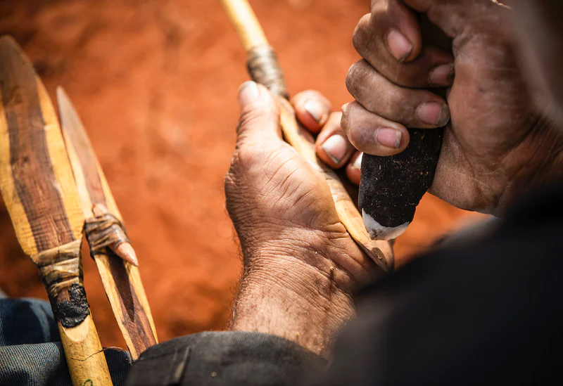 Close up of a man's hands crafting indigenous tools